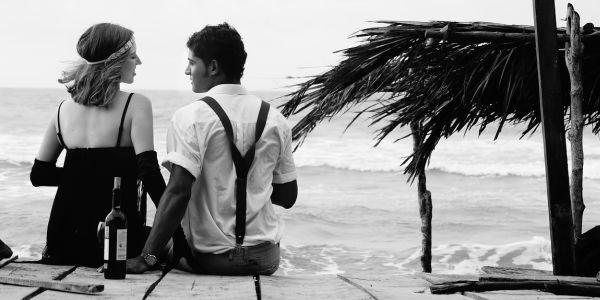 black and white shot of a couple by the beach