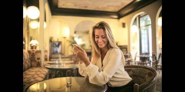 woman in a bar texting on her phone